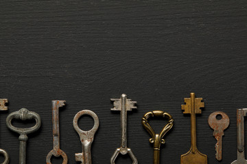 flat lay with vintage rusty keys on black background