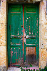 Weathered green wooden door entrance to a stone house in Lebanon