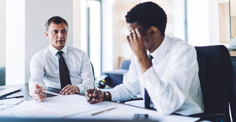 Multiethnic partners having discussing while working on project in office