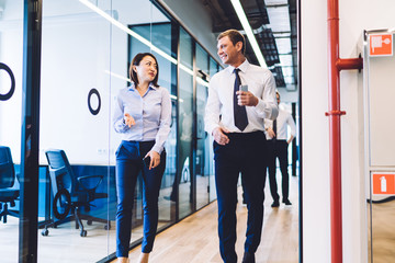 Glad multiethnic office employee dialoguing at office