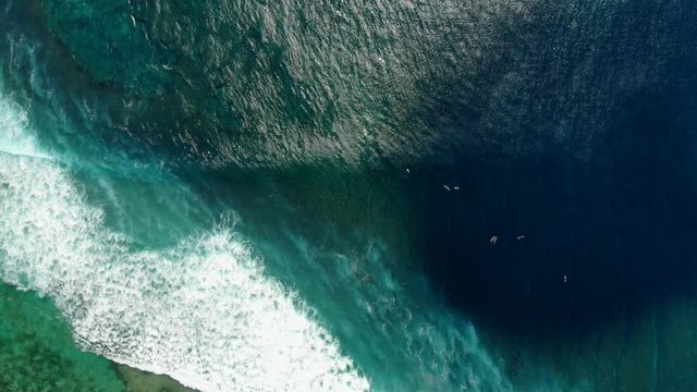 Aerial view of surfing at waves. Blue waves in ocean and surfers