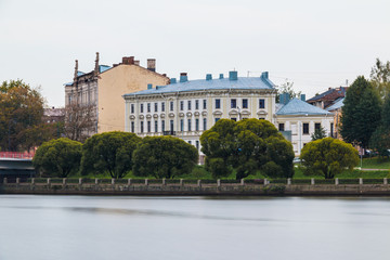 Obraz premium Embankment of the 30th Guards Corps with trees and apartment buildings in overcast day, Vyborg, Leningrad Oblast, Russia