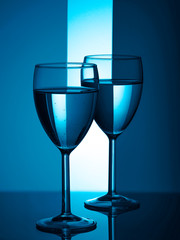 Two wine glasses silhouette full on blue background. Trendy color of the year 2020.