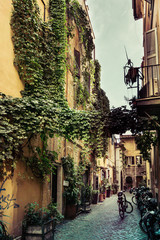Narrow street in Rome with cobble stone and bicycles © Kevin