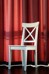 White chair on the background of the curtains
