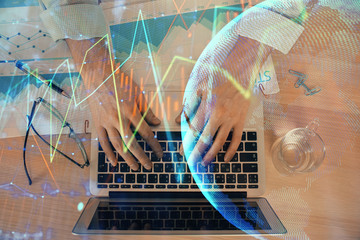 Double exposure of market chart with man working on computer on background. Concept of financial analysis.