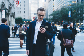 Handsome businessman with phone in center of downtown
