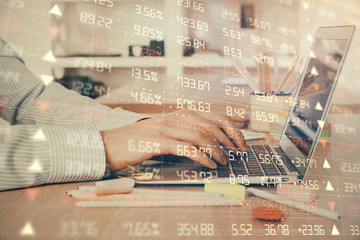 Double exposure of stock market graph with man working on laptop on background. Concept of financial analysis.