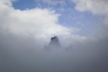 mountain with flag in the clouds