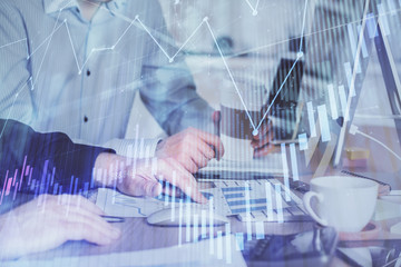 Multi exposure of chart with man typing on computer in office on background. Concept of hard work.