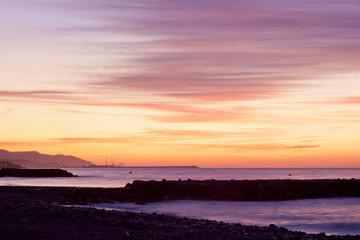 Sunrise seascape on Cubelles shore with Vilanova i la Geltru on background
