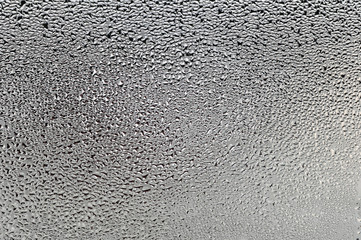 Drops of water on wet glass. Thaw, melts, ice on the window.