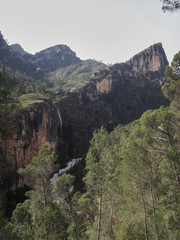 Fototapeta na wymiar A waterfall falls on the Guadalquivir River in the Natural Park of the Sierra de Cazorla, Segura and Las Villas. In Jaén, Andalusia. Spain