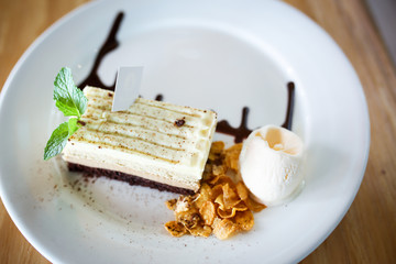 Delicious cake on white plate on table on light background.