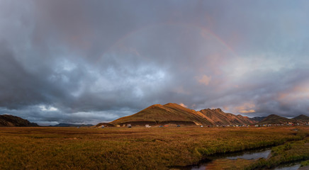Fototapeta premium Iceland in september 2019. Great Valley Park Landmannalaugar, surrounded by mountains of rhyolite and unmelted snow. In the valley built large camp. Evening in september 2019