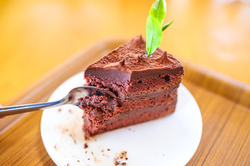 Delicious cake on white plate on table on light background.