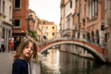 Fototapeta na wymiar cute little girl near a water canal in Venice italy