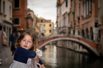 Fototapeta na wymiar cute little girl near a water canal in Venice italy