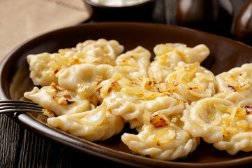 Mashed potato stuffed dumplings, served with fried onion and sour cream, Russian and Polish style cuisine. 