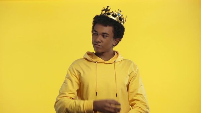 african american teenager wearing crown isolated on yellow
