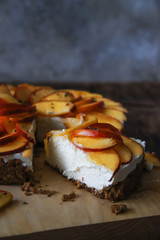 Homemade cheesecake with peaches. Healthy fruit dessert with cream cheese, nectarines, honey and thyme on wooden board. Diet cake. Paleo, low carb or keto food concept