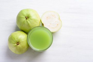 Green guava fruit and guava juice in glass on white background, high vitamin C healthy drink