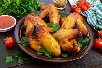Baked chicken teriyaki wings in honey mustard sauce with adjika and mustard on dark wooden table.  Asian recipe. Rustic style