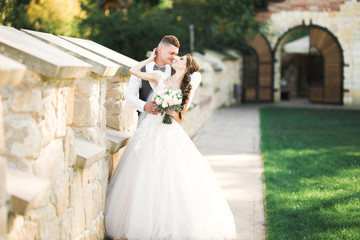 Wedding couple on the nature is hugging each other. Beautiful model girl in white dress. Man in suit