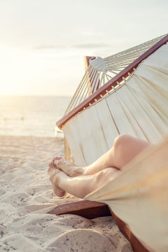 Peaceful woman napping in a hammock at the beach