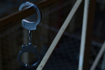 Black and white Handcuffs on the handrail on a prison or arrest background. Concept: problems with the law, criminal, offenses, waiting for the verdict of the judge, balancing on the border of the law