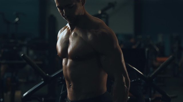 Muscular bodybuilder fitness men pumping up shoulders muscles workout fitness and bodybuilding concept background - Handsome strong athletic men doing delts exercises in gym naked torso