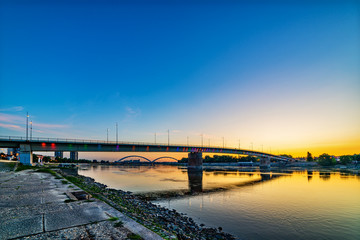 Novi Sad, Serbia August 10, 2019: Rainbow bridge (Serbian: Most Duga), Novi Sad, Serbia. Bridge Varadinska duga over Danube river. Kay Victim of the raid (Serbian: kej žrtava racije) Memorial park.