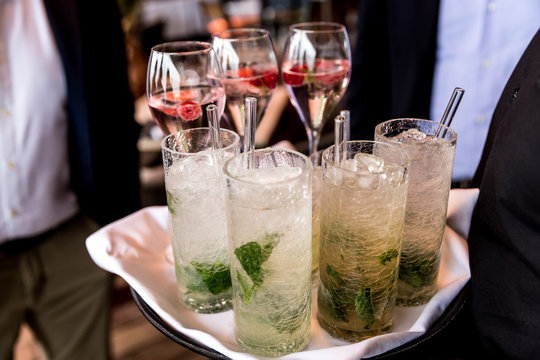 Kellner tr&auml;gt Tablett mit Cocktails und Aperitif