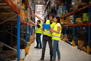 Workers in warehouse review the goods