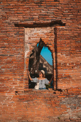 Tourist girl a portrait of fashion by pattern dot dress and jeans with sunglasses in Historic site at Ayutthaya Thailand