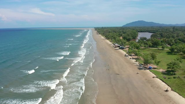 4K Aerial footage view of ocean waves crashing on Beautiful beach by at Sabandar Beach, Tuaran, Sabah, Malaysia