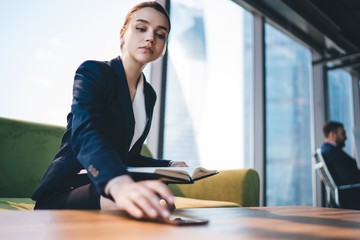 Businesswoman with notebook using smartphone