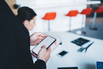 Crop boss using smartphone during meeting