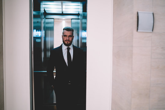 Thoughtful Businessman Standing And Looking Away While Elevator Doors Closing