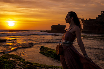 Woman against Pura Tanah Lot temple , Bali