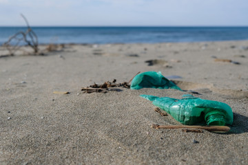 Green Plastic bottle on sea coast, pollution ecosystem planet save concept, 4k