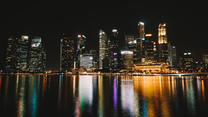 Fototapeta na wymiar La ville de Singapour de nuit avec les reflets des lumières sur le fleuve