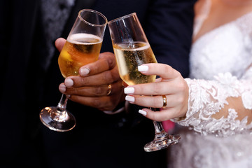 Hands with wedding rings holding champagne glasses