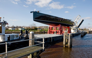 Fototapeta na wymiar Transport of a Super sailing yacht. on the river. Netherlands. Shipyard. Shipbuilding industry.