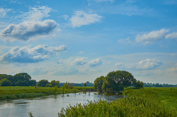 Peaceful rural summer european landscape with green trees and water