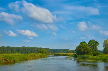 Peaceful rural summer european landscape with green trees and water