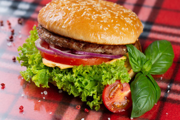  pork burger with cheese, tomatoes, cucumber, onions. bun with sesame seeds and bacon