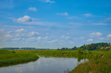 Peaceful rural summer european landscape with green trees and water