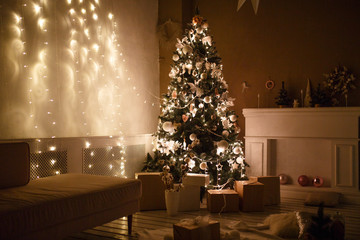 Decorated for the new year interior of the house-the General plan. Christmas tree and decorated Studio, lights garlands, decorations, gift boxes in a cozy home.