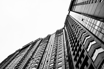 geometric residential building in black and white towering over the streets of the city